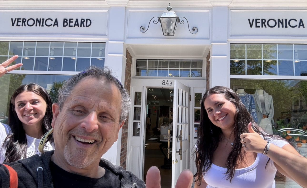 Two women and man smile outside Veronica Beard store.