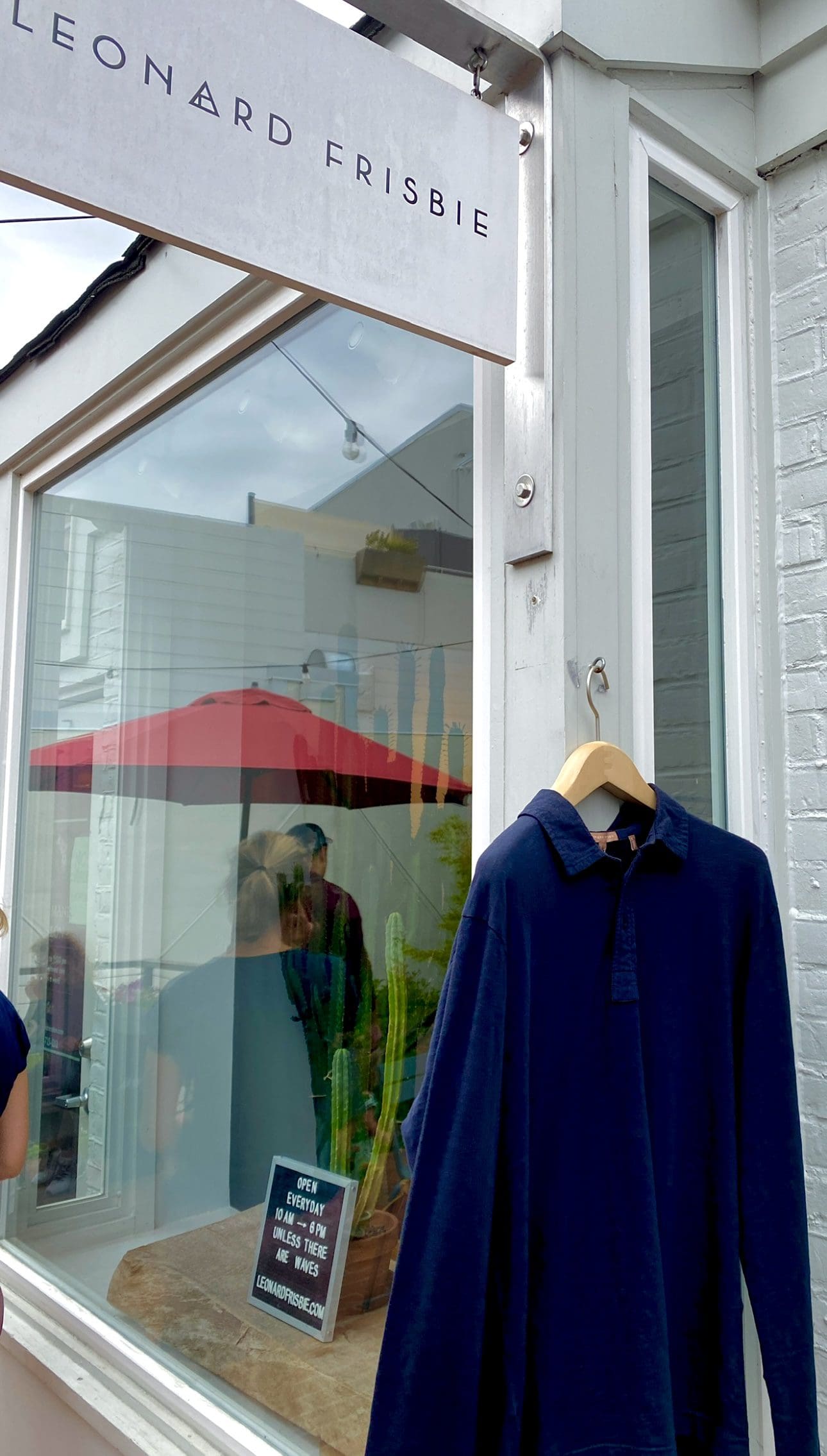 Blue shirts displayed on wooden hangers in store.