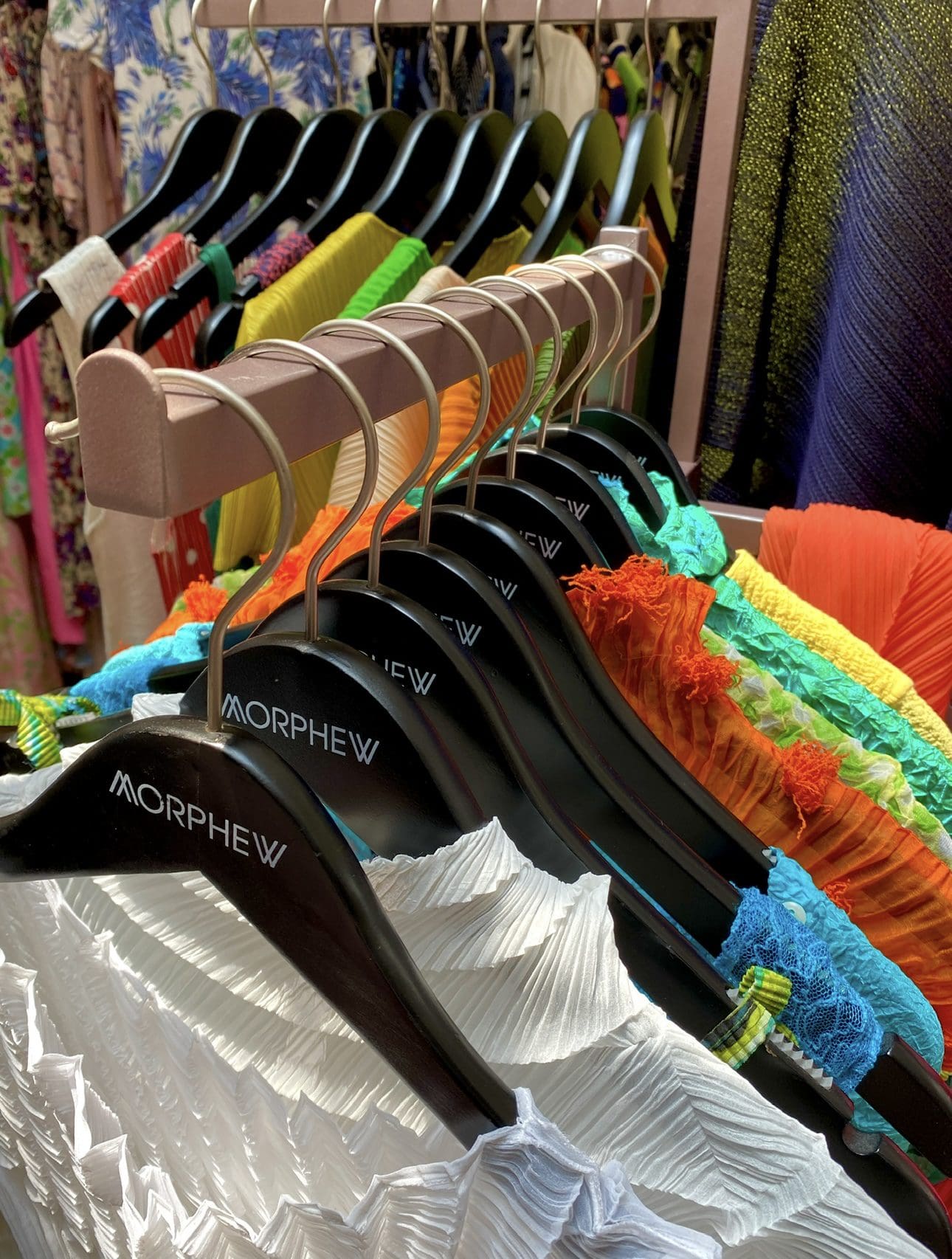 Colorful dresses hang on "Morphew" hangers, showcasing styles.