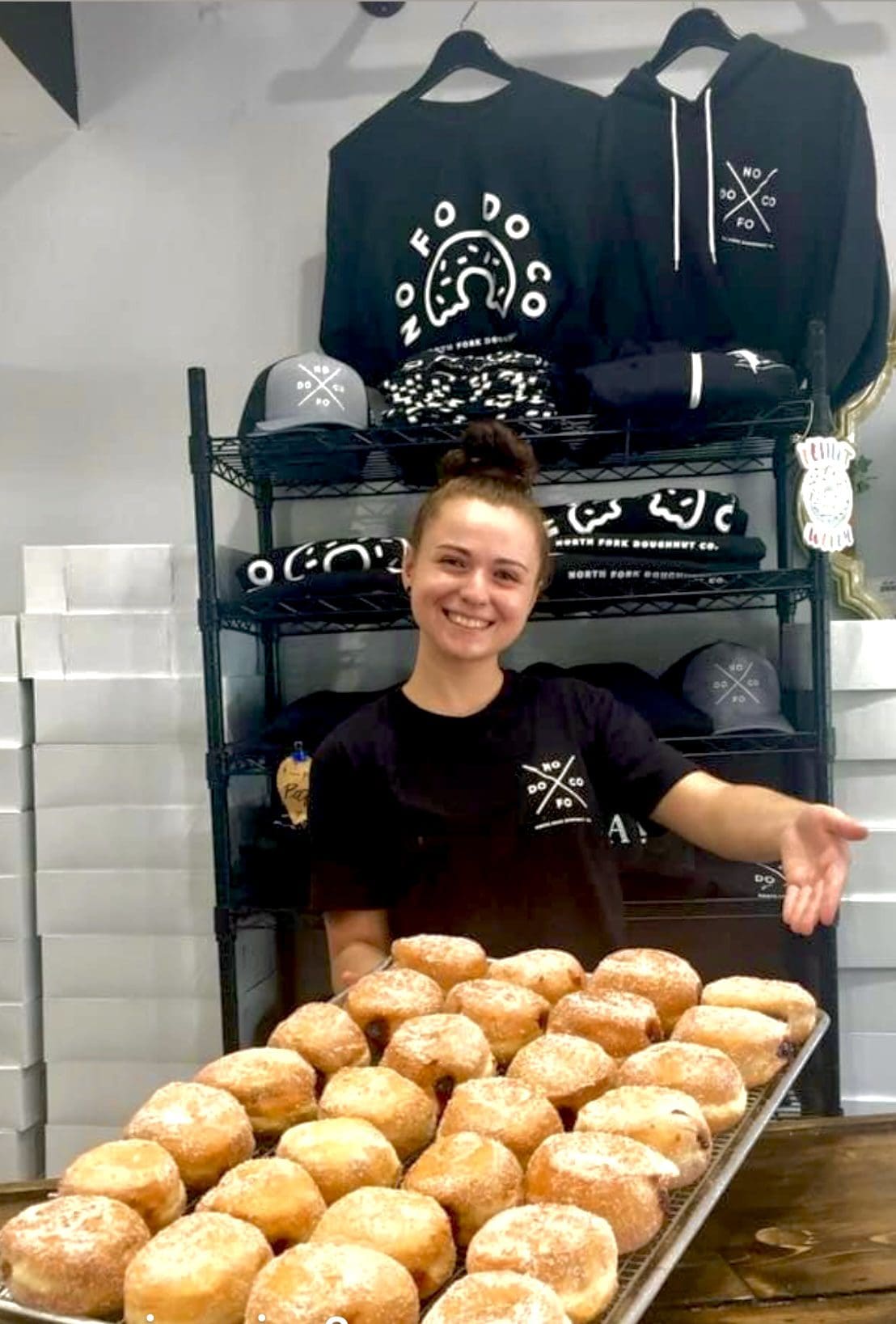 North Fork Doughnut Co. employee offers fresh doughnuts.