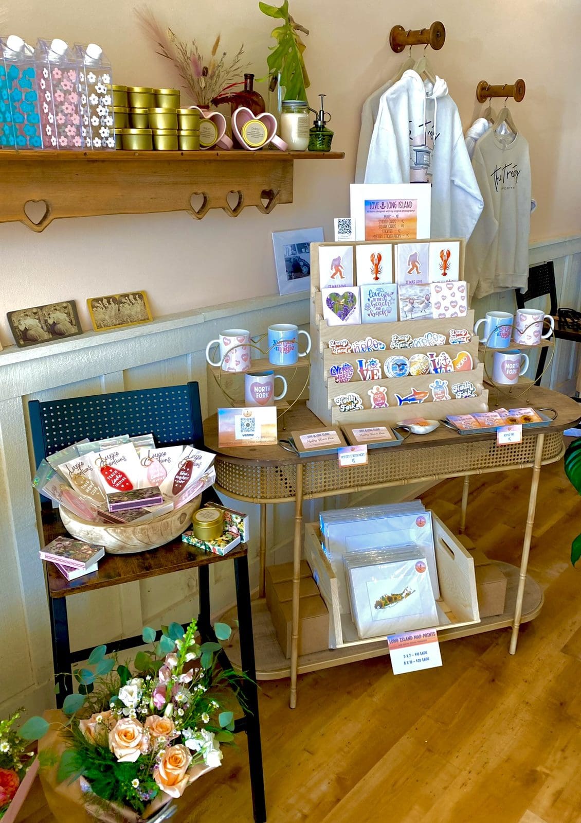 Cozy shop display with mugs, stickers, candles, plants.