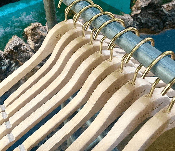 Wooden hangers neatly arranged on metal rack.