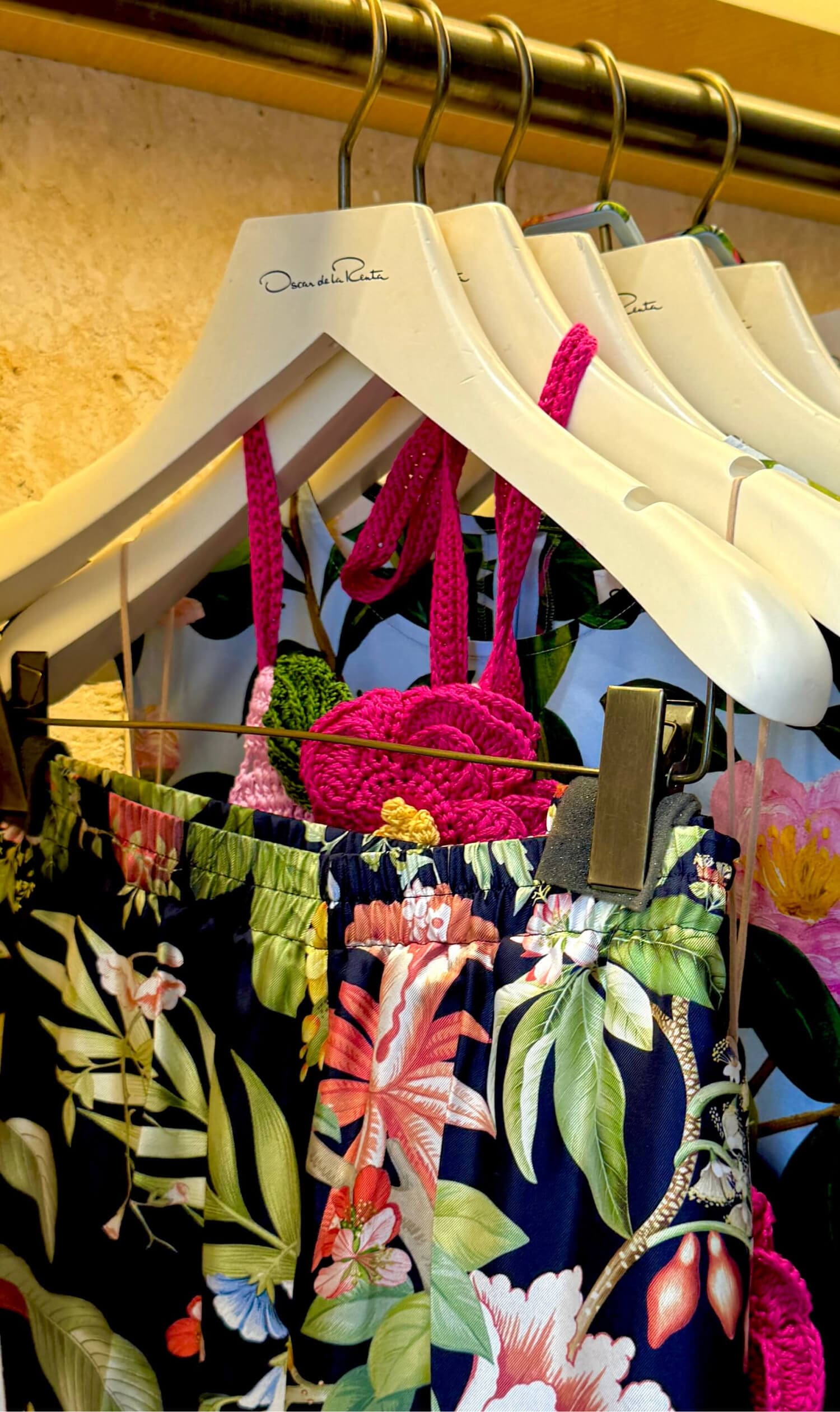 Colorful floral clothing on white hangers, summer collection.