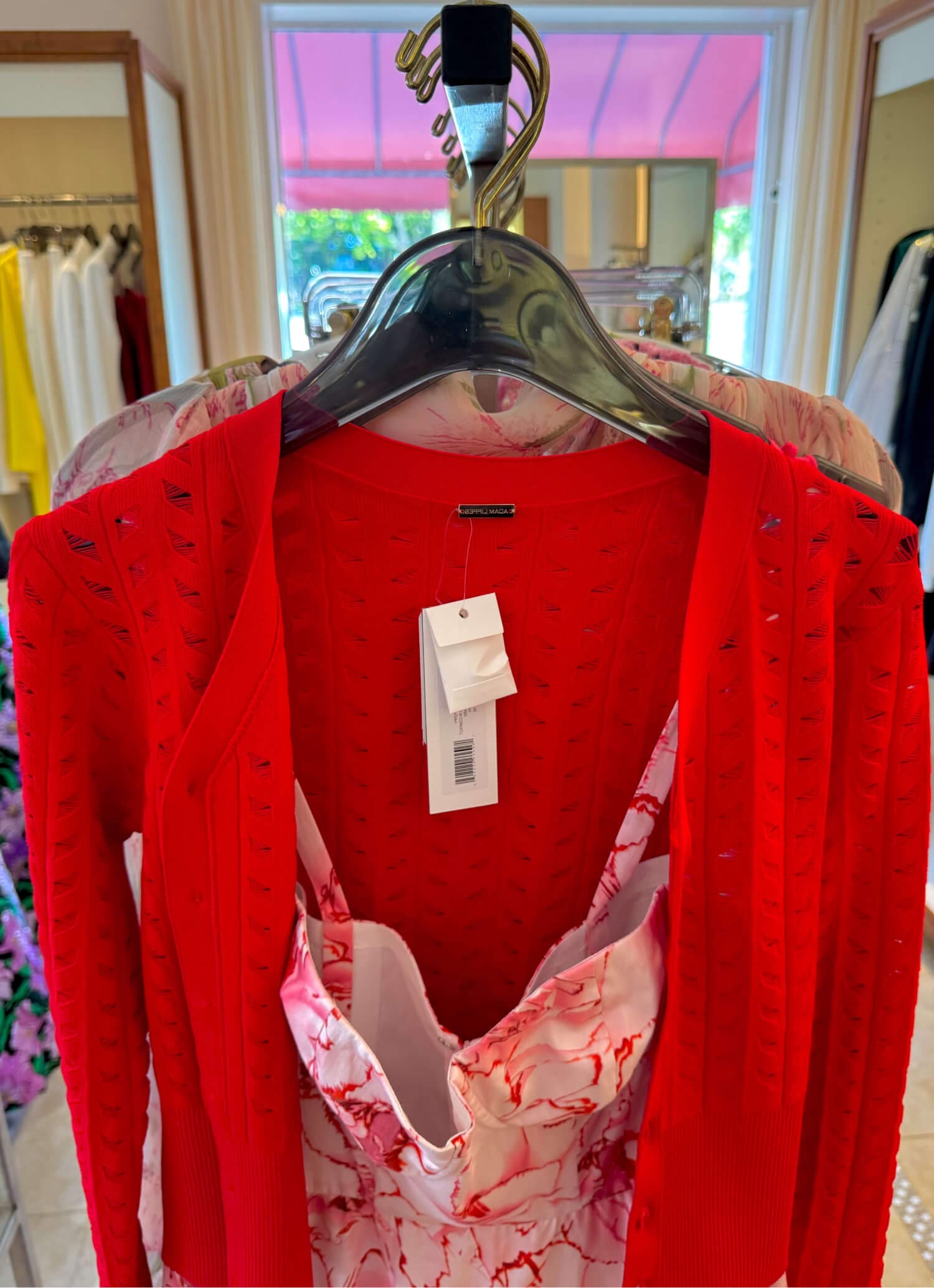 Bright red cardigan with floral dress, trendy retail display.