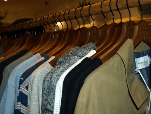 Clothing on wooden hangers showcases diverse styles.
