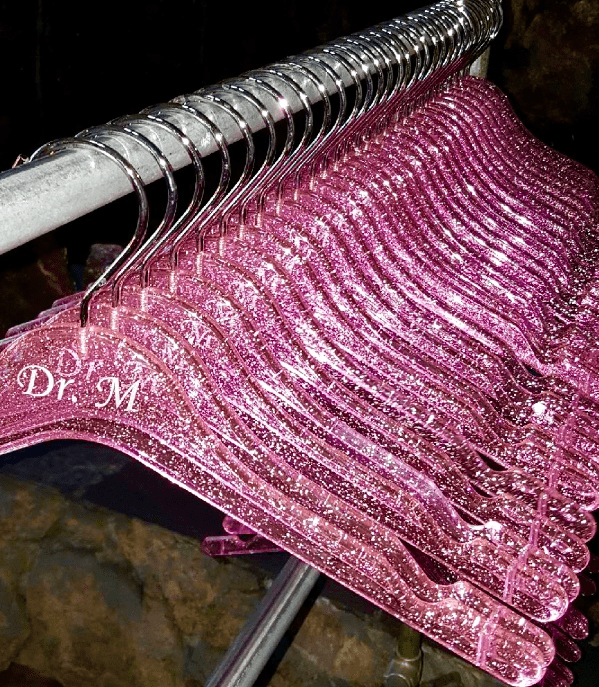 Sparkly pink “Dr. M” hangers on metal rack.