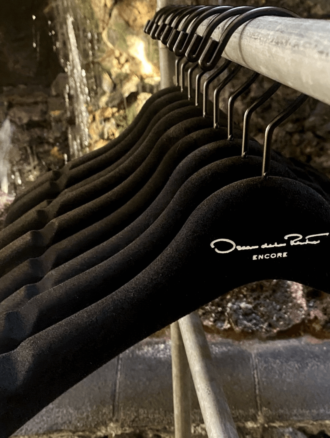 Black velvet Oscar de la Renta Encore hangers displayed neatly.