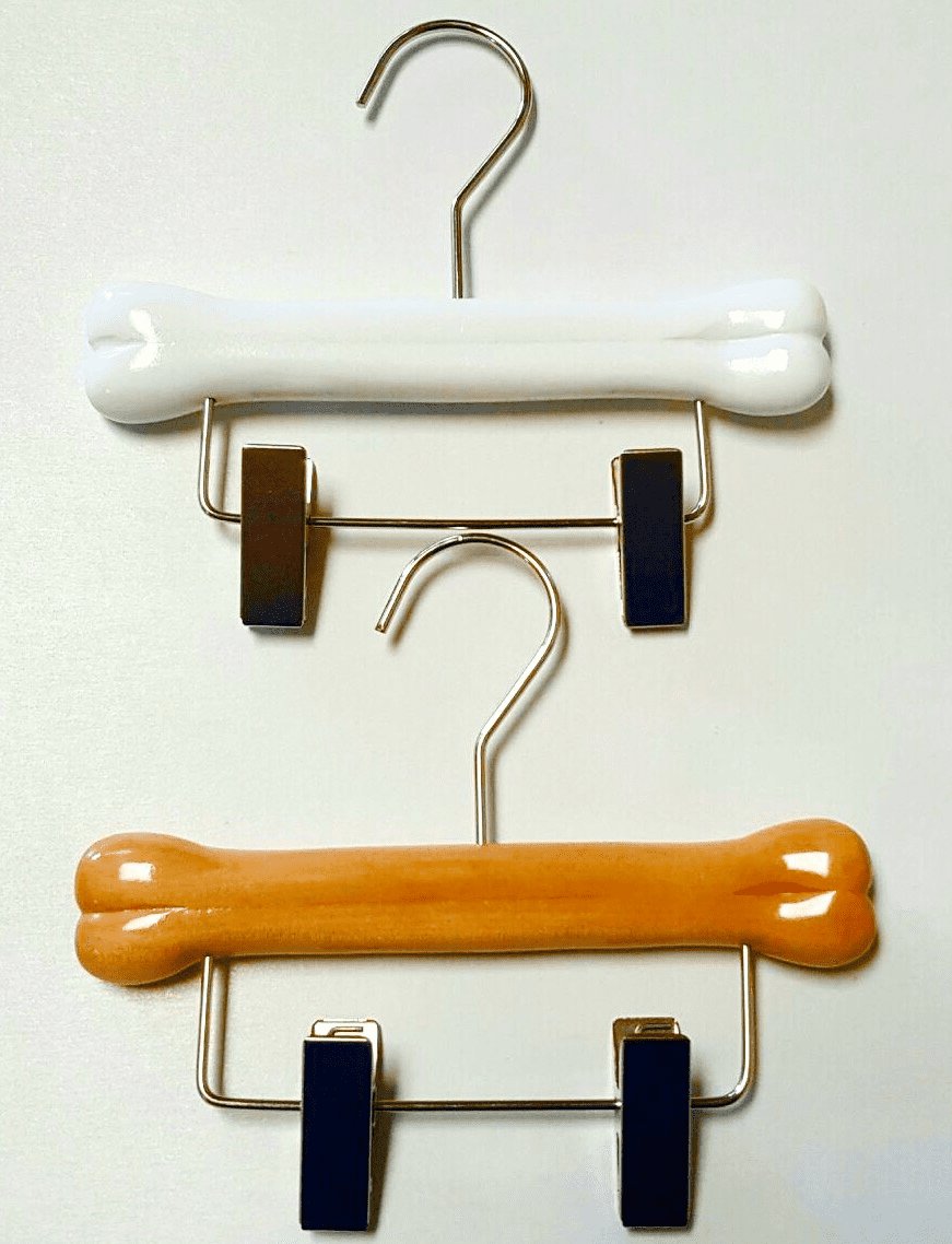 Two clip hangers shaped like dog bones, one white and one orange, secured with black clips, displayed against a white background.