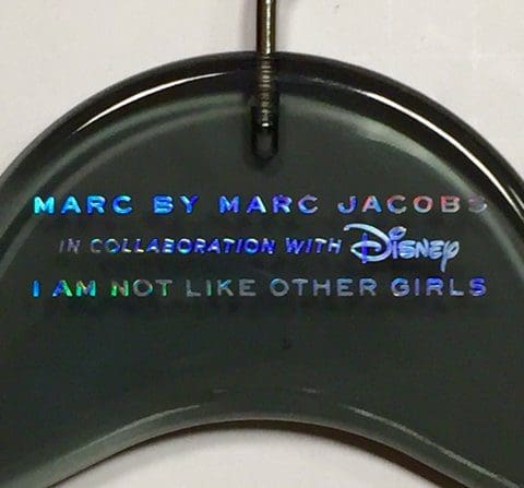 Hanger displaying the text: "Marc by Marc Jacobs in collaboration with Disney. I am not like other girls." Highlights a fashion collaboration's unique message.