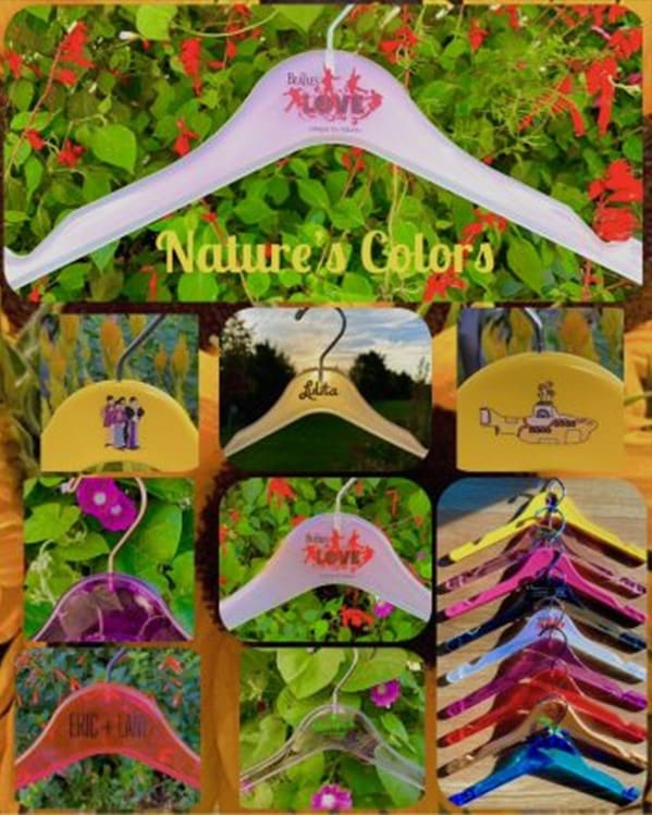 Colorful hangers display art against vibrant green backdrop.